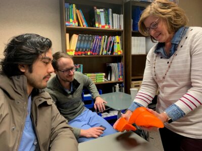 Professor Dina Peterson with students and her new 3D-printed segmented liver model.